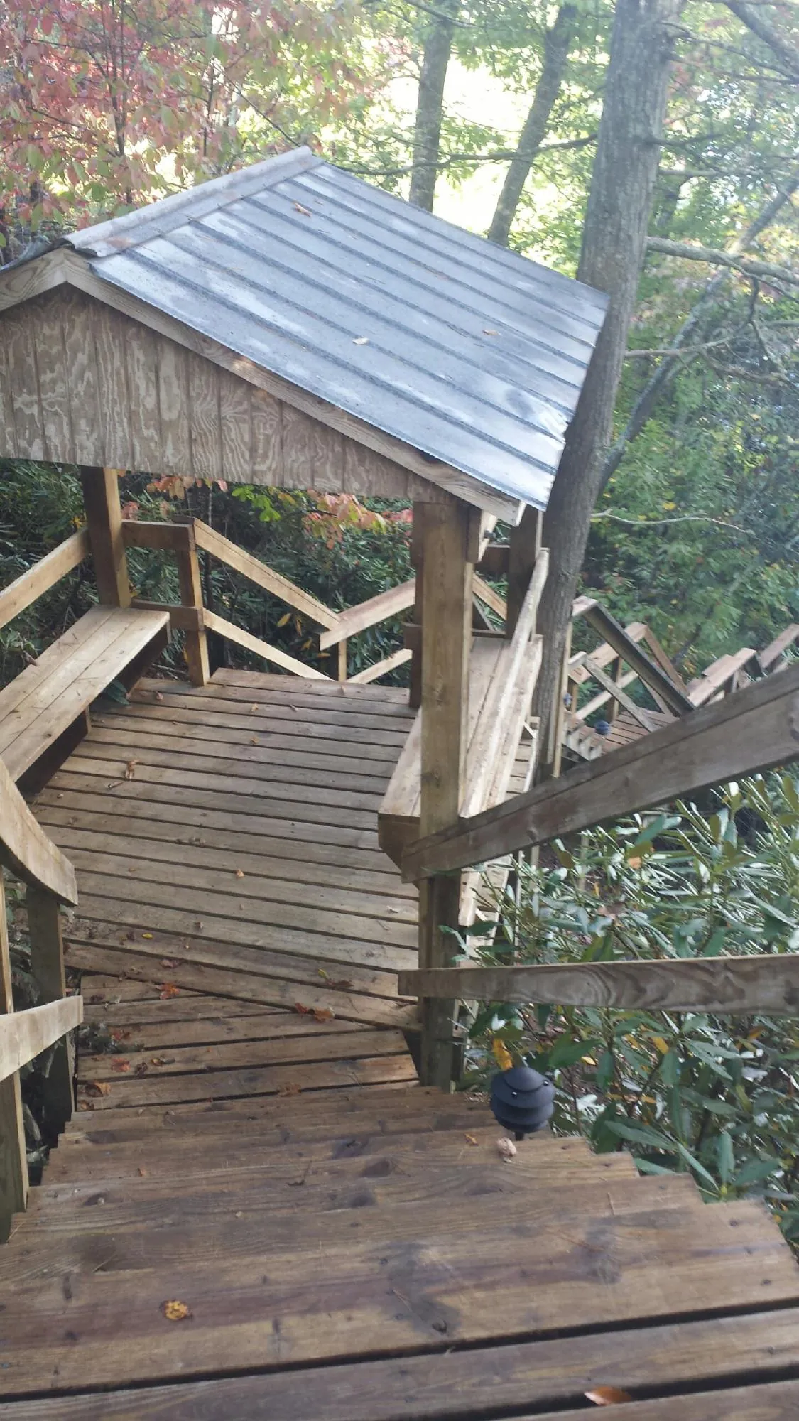 Metal roofed shelter over wooden steps on a wooded walkway — Skylight Repair & Installation work by our crew in Belen