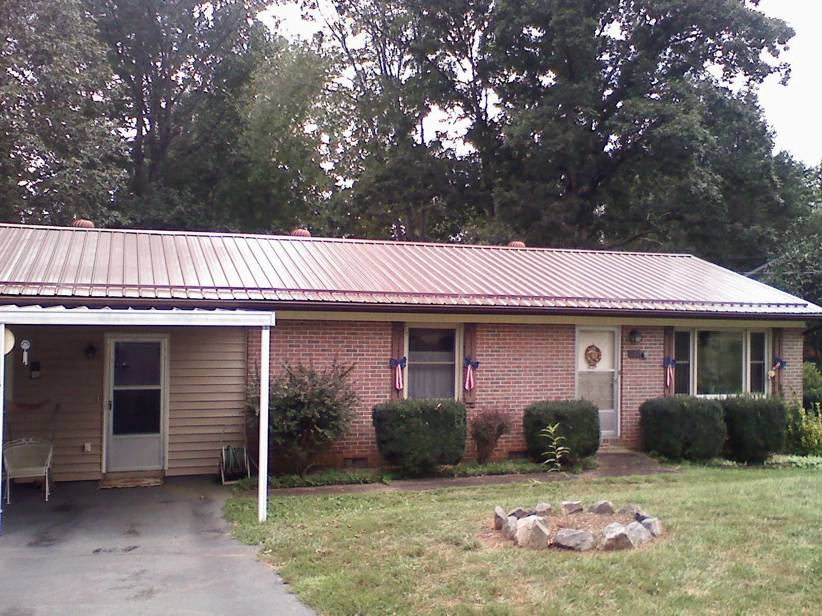 Bronze metal roof and carport on a brick ranch home — Roof Repair work by our crew in Belen