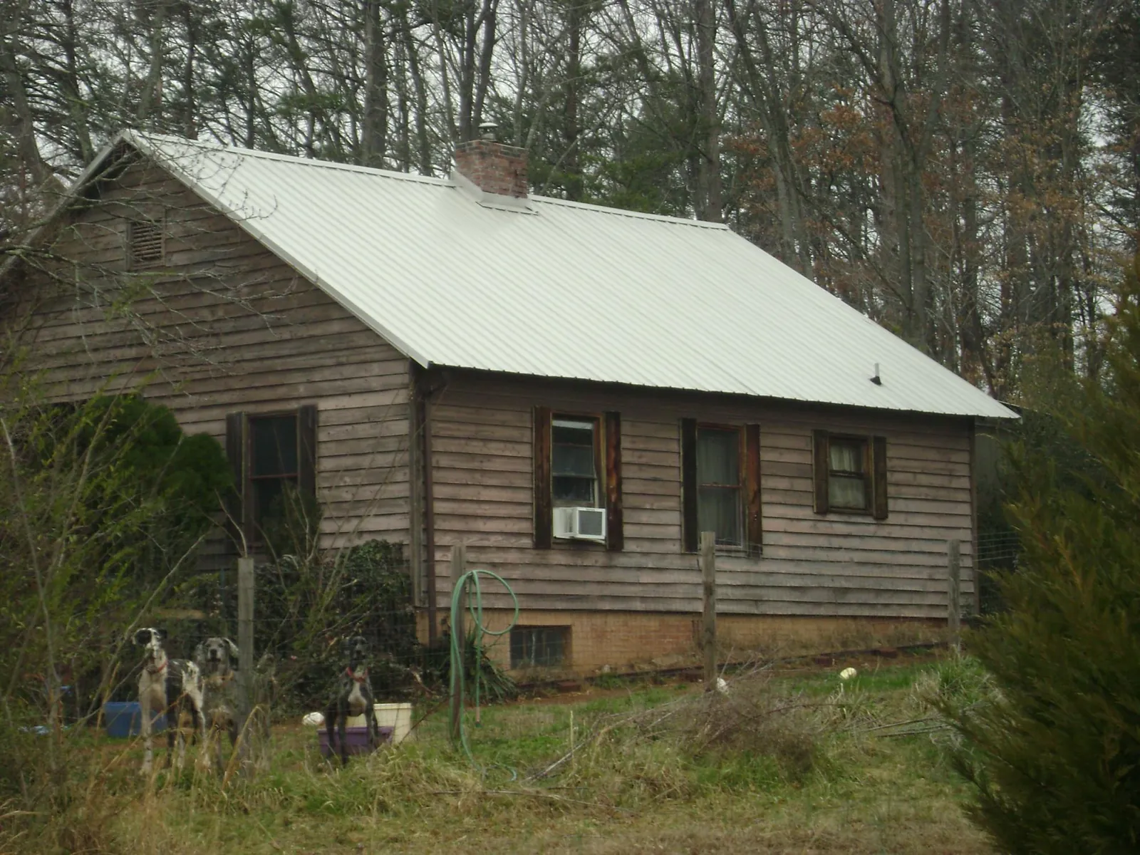White metal roof on an old wood sided farmhouse, from a Metal Roof Installation job in Belen